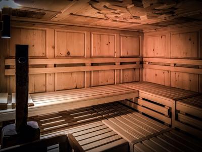 Sauna en bois clair avec bancs en gradins et éclairage chaud pour des moments de détente à l'hôtel.