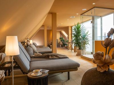 Gemütlicher Lounge-Bereich mit modernen Sesseln, warmem Licht und Pflanzen im Hotel.
