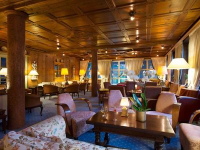 Eleganter Hotel-Loungebereich mit Holzvertäfelungen, Sofas und warmem Licht.