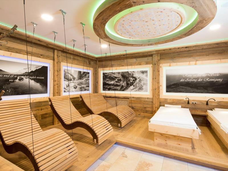 Odpočinková místnost s ergonomickými dřevěnými lehátky, teplým osvětlením a fotografiemi přírody na stěnách.