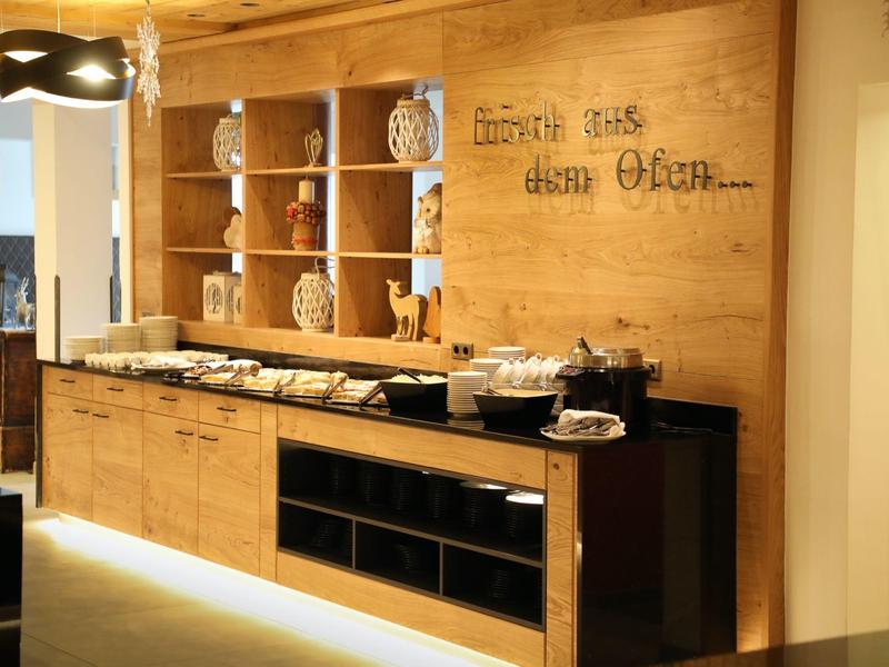 Moderní snídaňový bufet s dřevěnými policemi a nádobím v hotelu.