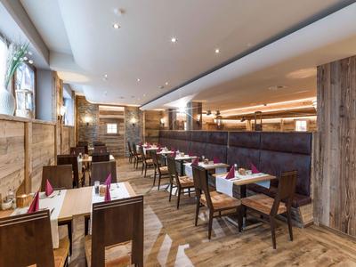 Modernes Restaurant mit Holzboden, Holzwänden und gedeckten Tischen mit Stühlen.