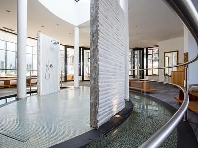Modern hotel lobby with circular water feature and large windows letting in natural light