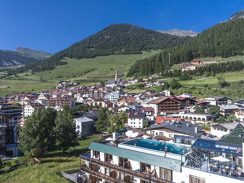 Mountain town with hotels and houses under a clear blue sky.