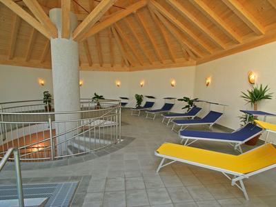 Salle de détente circulaire avec transats et plafond en bois dans une ambiance calme.