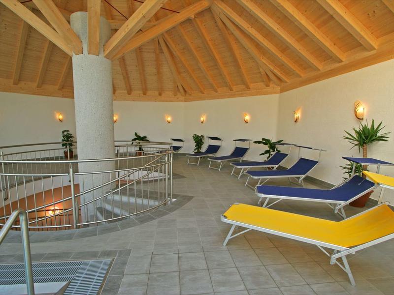 Salle de détente circulaire avec transats et plafond en bois dans une ambiance calme.