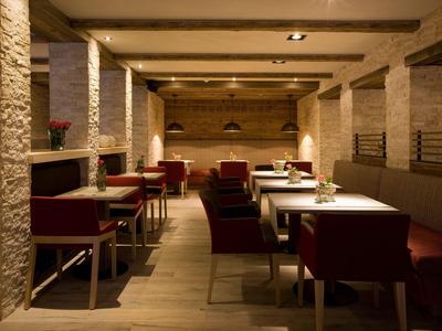 Salle à manger moderne et chaleureuse avec murs en bois et piliers en pierre beige.