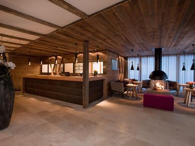 Coin salon d'hôtel chaleureux avec boiseries, cheminée et sièges.