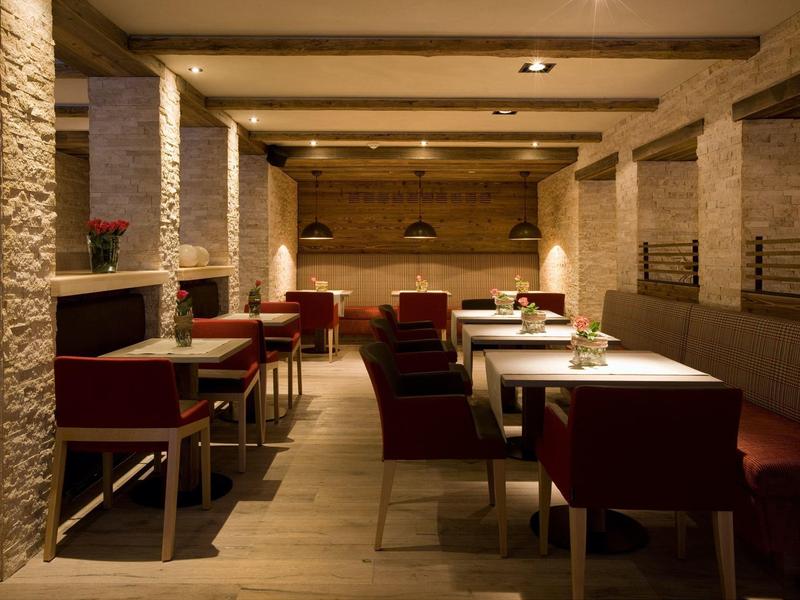 Cozy, modern dining area with warm lighting and red chairs.