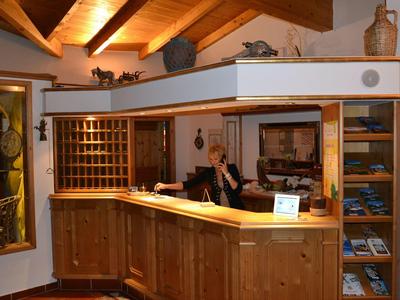 Réception d'hôtel chaleureuse avec comptoir en bois et porte-clés sous un plafond en bois.