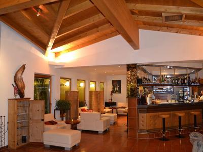 Living area with cozy seating and bar counter under wooden ceiling beams.