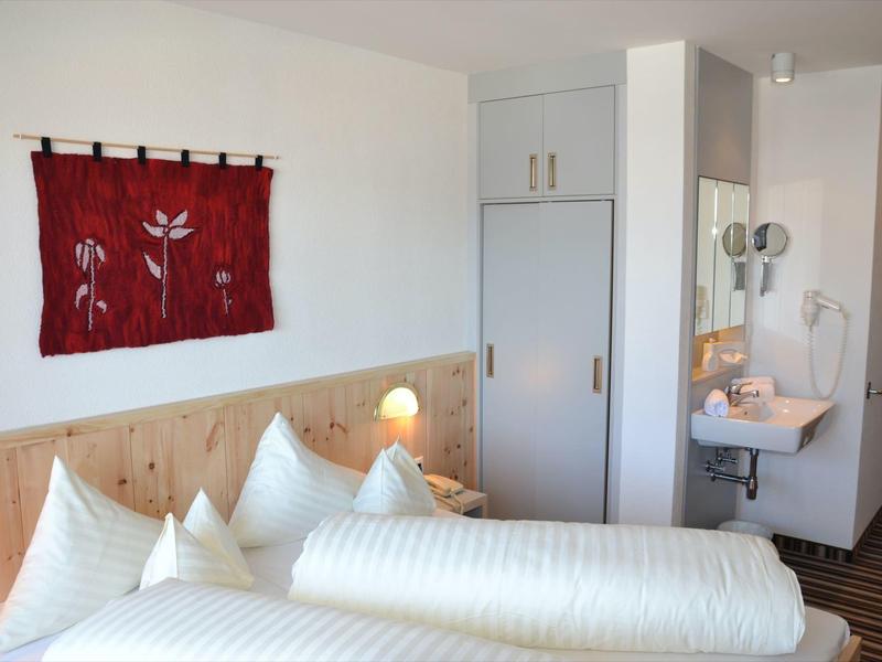 Habitación de hotel acogedora con cama doble, muebles de madera y moqueta.