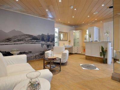 Modern gestalteter Eingangsbereich mit hellem Holzfußboden, weißen Möbeln und großem Landschaftsfoto an der Wand.