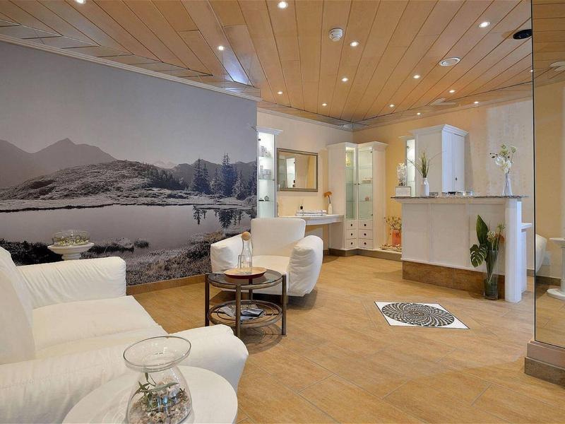 Modern gestalteter Eingangsbereich mit hellem Holzfußboden, weißen Möbeln und großem Landschaftsfoto an der Wand.