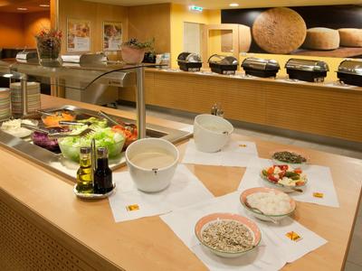 Buffet with salads and dips in a bright hotel restaurant.