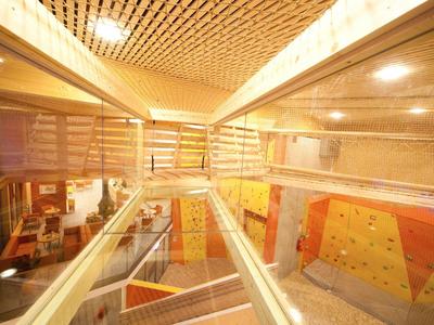 Modern interior with stairs, glass railings, and light wood decor in a building.
