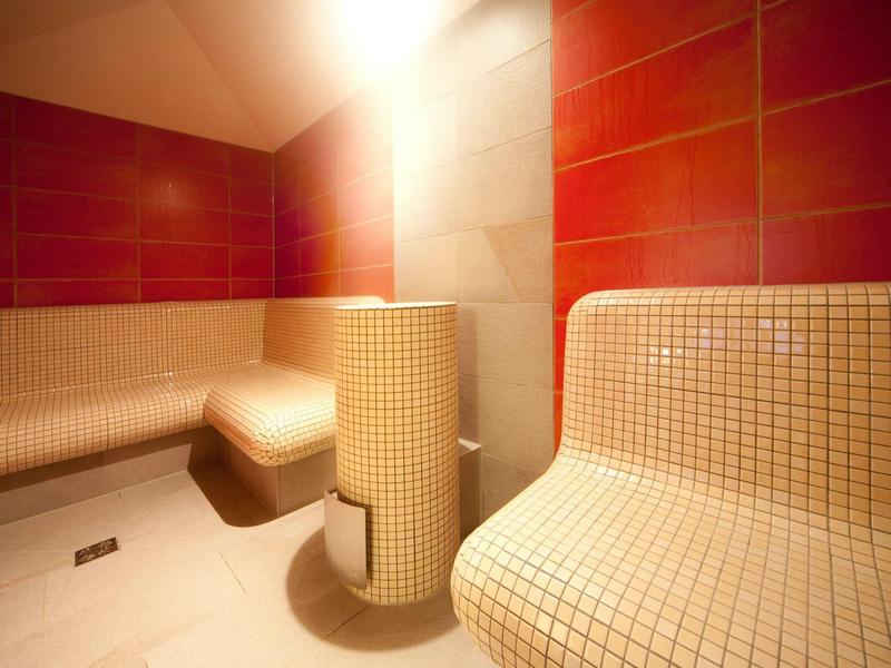 Modern sauna with red and white tiles and curved benches