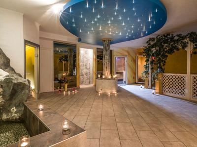 Couloir d'hôtel élégant avec plafond étoilé, plantes et éclairage créant une ambiance détendue.