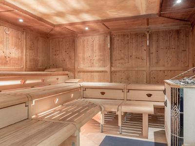 Sauna room with wooden benches and a heater in the corner.
