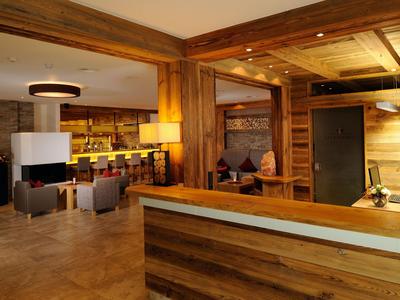 Accogliente area lounge dell'hotel con pannelli in legno e posti a sedere comodi.