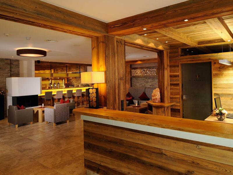 Accogliente area di ricevimento dell'hotel con pannelli in legno e posti a sedere comodi.
