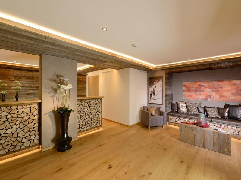 Soggiorno moderno con pavimento in legno, divani in pelle e tessuto e camino decorativo.