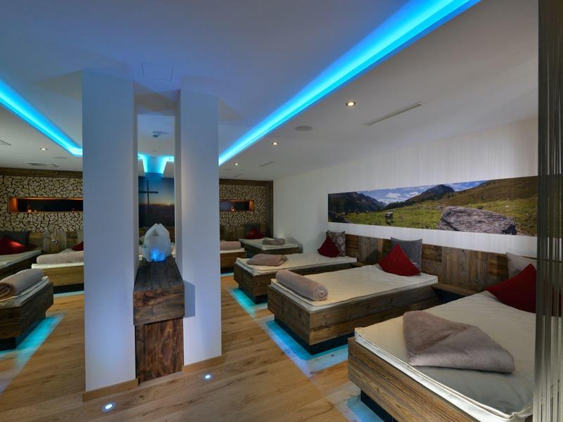 Sala spa moderna con lettini, illuminazione d'atmosfera e decorazioni paesaggistiche rilassanti.