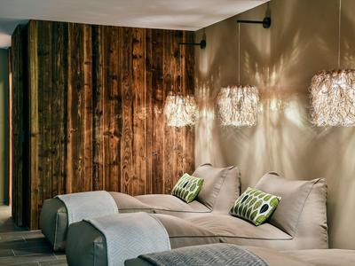 Cozy hotel room area with two single beds, wooden wall, and decorative lamps