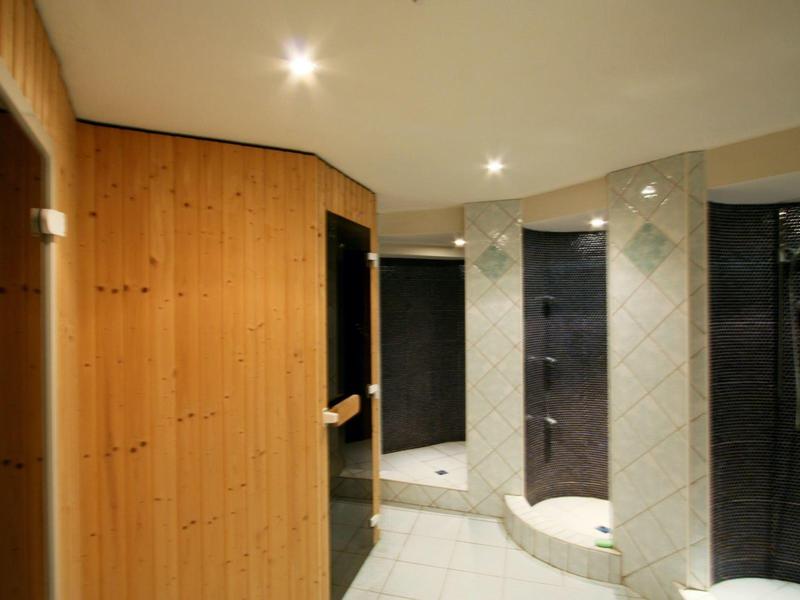 Vestiaire moderne avec murs en bois et douches sombres simples dans un espace lumineux