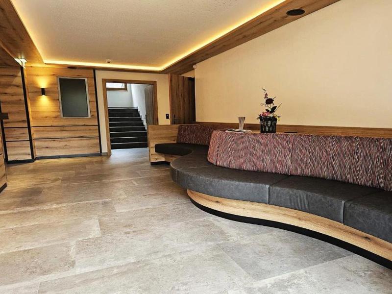 Espace d'attente moderne avec canapé courbe et accents bois chaleureux dans un hôtel.