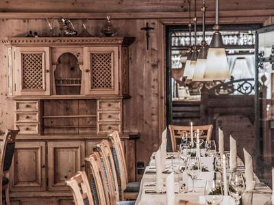 Rustikaler Speiseraum mit Holzmöbeln, Kerzen und eleganter Tischdekoration in einem Hotel.