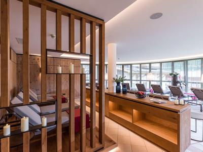 Moderner Hotel-Loungebereich mit Holzakzenten, großen Fenstern und komfortablen Sitzgelegenheiten.