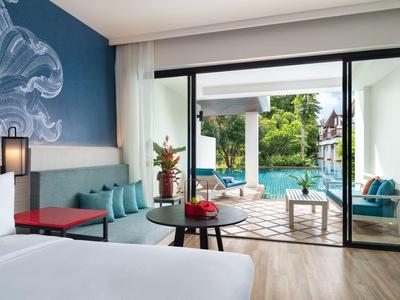 Modernes Hotelzimmer mit Doppelbett, blauem Akzent, Terrasse und Blick auf den Pool.
