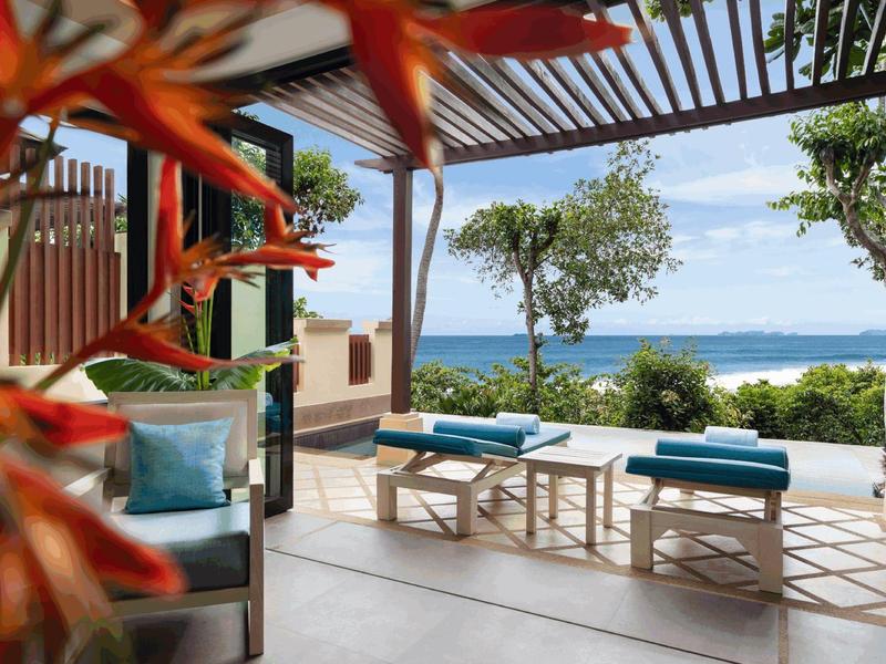 Terrasse mit Sitzbereich und Ausblick auf das Meer unter blauem Himmel