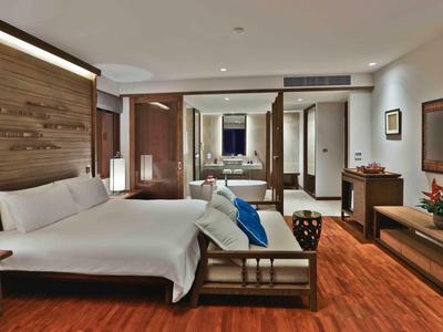 Modernes Hotelzimmer mit Doppelbett, Holzfußboden und eleganter Einrichtung.