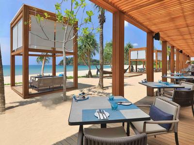 Moderner Strandbereich mit Holzpavillons, Tischen und Stühlen neben dem Meer