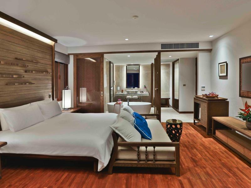 Modernes Hotelzimmer mit Doppelbett, Holzfußboden und eleganter Einrichtung.