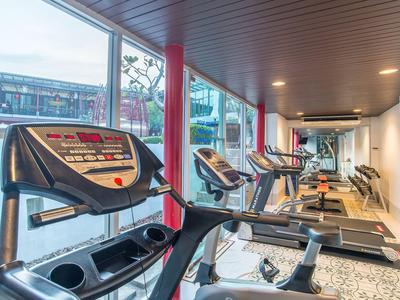 Moderner Fitnessraum mit Laufbändern und großen Fenstern mit Blick auf die Stadt