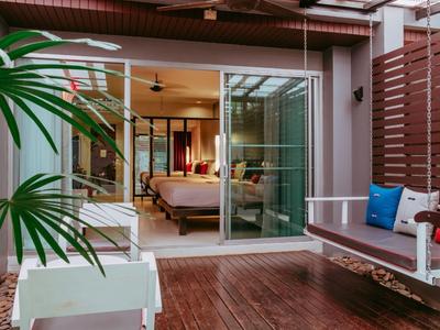 Gemütliche Terrasse mit Holzboden, Sitzbank und Blick in ein Schlafzimmer durch Glas-Schiebetüren.