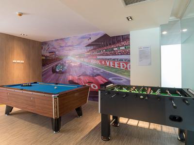 Spielzimmer mit Billardtisch und Kicker vor einer Wand mit Rennsport-Wandbild