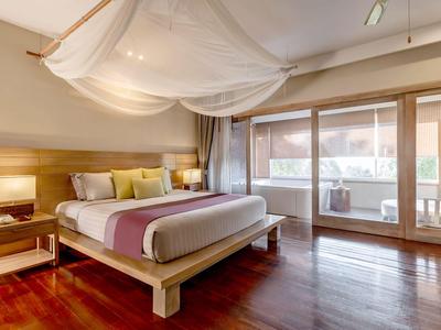 Modernes Schlafzimmer mit großem Bett, Baldachin und Zugang zu einem Balkon.