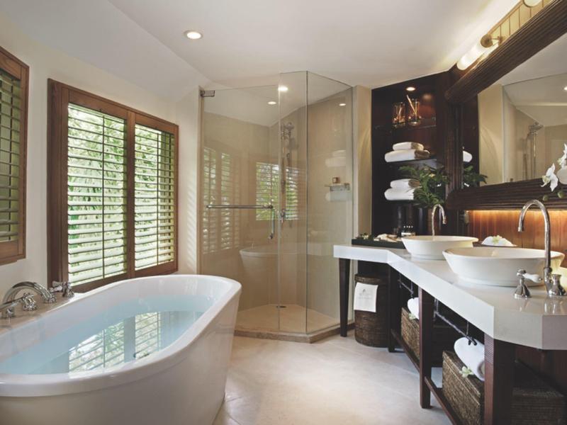 Modernes Badezimmer mit freistehender Badewanne, Glasdusche und Doppelwaschbecken.