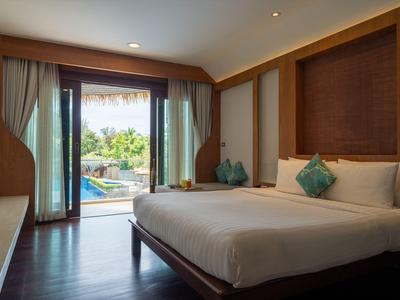 Modernes Hotelzimmer mit großem Bett und Blick auf Pool durch offene Glastür