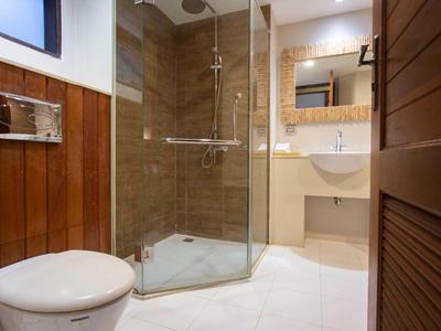 Helles Badezimmer mit Glasdusche, weißem WC und Waschtisch mit Spiegel.