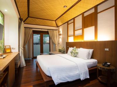 Modernes Hotelzimmer mit Doppelbett, Holzboden und Zugang zu einer Terrasse.