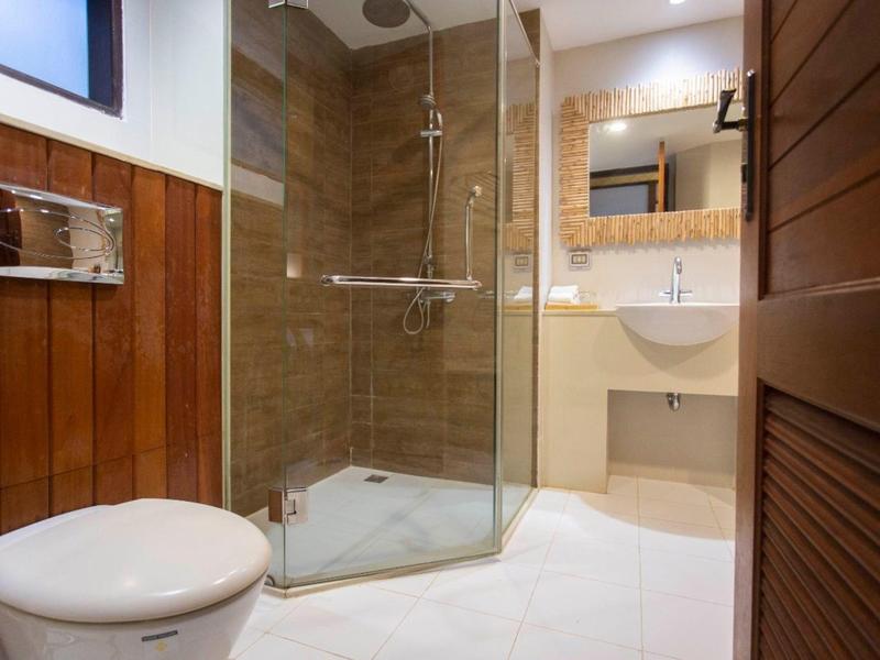 Helles Badezimmer mit Glasdusche, weißem WC und Waschtisch mit Spiegel.