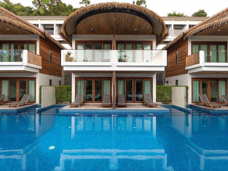 Hotel mit modernen Holzbalkonen und blauer Swimmingpoolfläche im Vordergrund