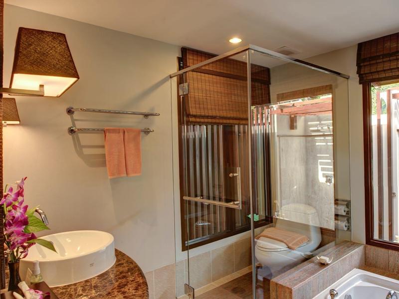 Helles Badezimmer mit Glasdusche, Waschtisch mit rundem Becken und Badewanne mit Holzverkleidung.