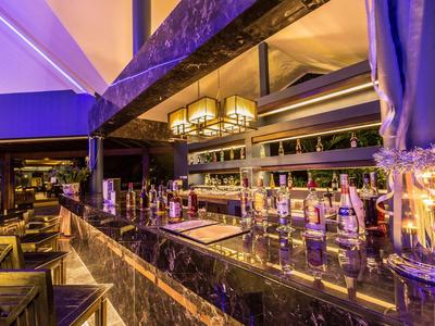 Moderní hotelový bar s posezením a osvětleným černým mramorovým pultem