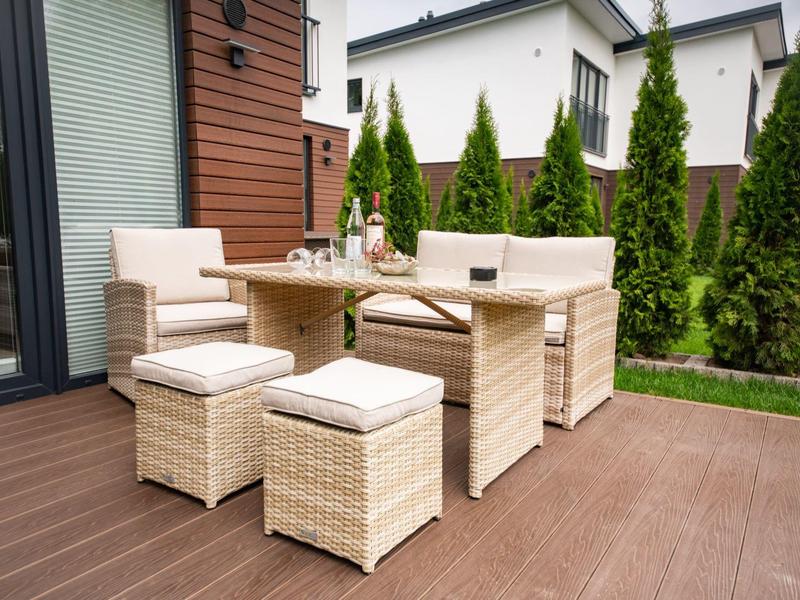 Cozy patio with rattan furniture overlooking a well-kept garden and houses